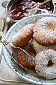 Ausgezogene (Bavarian-style doughnuts) in a light blue bowl with pastry tongs