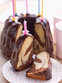 Marble cake with chocolate glaze and birthday cake candles