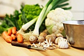 An arrangement of vegetables: carrots, spring onions, cauliflower, turned mushrooms
