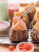 Mini house-shaped cakes being decorated with icing