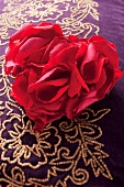 Rosenblütenblätter in Herzform auf perlenbesticktem Kissen