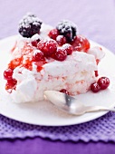 A slice of Pavlove with berries on a plate