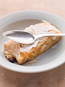 A slice of apricot strudel with a spoon