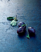 Three plums with leaves