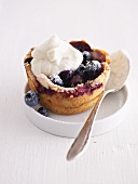 A blueberry tartlet with a dollop of cream