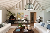 A living room with white upholstered furniture, a solid wooden coffee table and a open grand piano