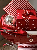 Christmas gifts and decorative bauble in red pram