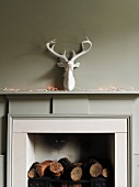 Fireplace decorated with logs, fairy lights and fake stag's head