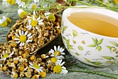 A cup of chamomile tea with chamomile flowers