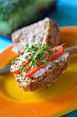 A seeded wholemeal roll with cottage cheese, tomatoes and cress