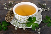 Wood sanicle (Sanicula europaea): tea, tea leaves and fresh herbs
