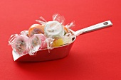 Sugar bonbons in cellophane paper on a scoop