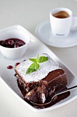 Chocolate cake with cherry sauce and coffee