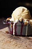 Individual Blackberry Crisp Topped with a Scoop of Vanilla Ice Cream; Melting