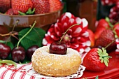 A doughnut with cherries, strawberries and dahlias