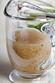Homemade Italian Vinaigrette Salad Dressing in a Small Glass Pitcher with a Whisk