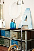 Old ornamental letters and blue soda siphons on vintage metal shelves with wooden top