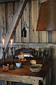 Candles and animal figurines on rustic table in wooden cabin