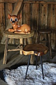 Bambi figurine on wooden stool in cabin