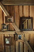 Photos with wooden frames on wall and wooden beams of cabin