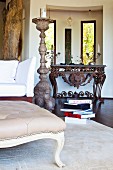 Grand, floor-standing candlestick in living room with Baroque console table made from rusty metal