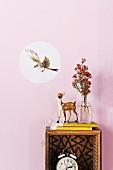Decorative sticker with picture of flying bird and deer ornament on upcycled box shelf on wall painted pastel pink