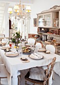 Set table in dining room with elegant period furniture, chandelier and dresser