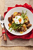 Gröstl (typical Tirolean dish using leftovers) with potatoes, pork, green beans and a poached egg