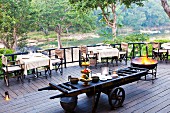 Restaurant terrace with buffet on rustic, agricultural trailer and set tables against backdrop of river landscape