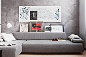 Seating area in harmonious shades of grey with chaise sofa and calligraphy on marbled wall