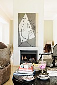 Colonial-style armchair and chair behind books and magazines on table in front of fireplace in partition below modern artwork