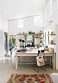 Bright, spacious kitchen with vintage furniture, rustic kitchen shelves and antique cooker below sloping, corrugated metal ceiling