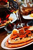 Maple Syrup Pouring Over Blueberry Pancakes
