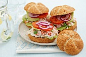 Home-made burgers with surimi salad, tomato, lettuce and red onion
