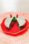 A green muffin with raspberries on a red plate