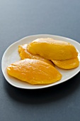 Several slices of mango on a plate
