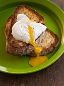 Poached Egg Over Toast with Runny Yolk; On a Green Plate
