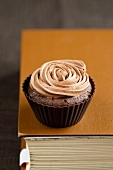 A chocolate cupcake with a rose made of icing