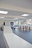 Long, futuristic designer bench and dining area in open-plan minimalist interior