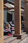 Sun loungers and parasols behind masonry columns on terrace of art deco hotel