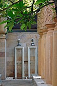 Twin outdoor showers on sandstone wall and impressive stone columns decorated with traditional patterns