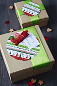 Festive gift boxes decorated with round patterned cards, green ribbons and Father Christmas boot