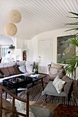 Metal chairs with seat cushions and retro table in Scandinavian-style interior with vaulted ceiling