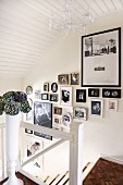Fotogalerie an Treppenaufgang mit weiss lackiertem Holz und Mosaikparkett