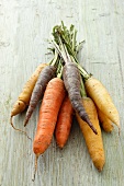 A selection of different coloured carrots (purple, yellow and orange)