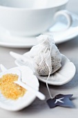 Small, feather-shaped plates holding brown sugar and a teabag