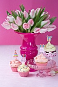 Cupcakes with party toppers and bouquet of tulips