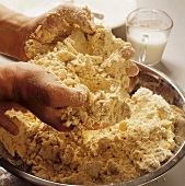 Hands Kneading Dough in a Metal Bowl