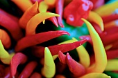 An assortment of colourful chilli peppers (close-up)