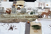 Weihnachtsdeko für den Esstisch: Blatt mit Goldglitter, Hirschfiguren und silberne Windlichter